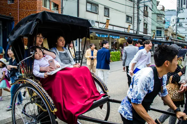 A rickshaw carrying passengers through a busy street