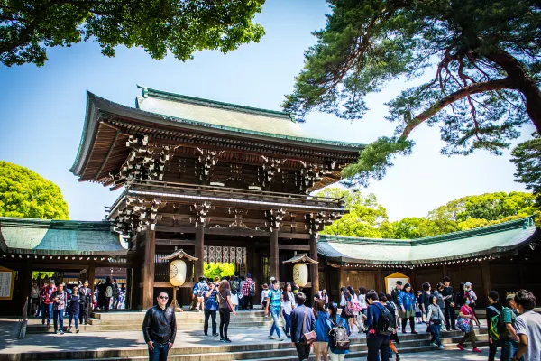 A wooden shrine gate framed by green branches