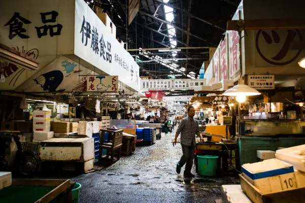 A covered market aisle lined with boxes and illuminated stalls