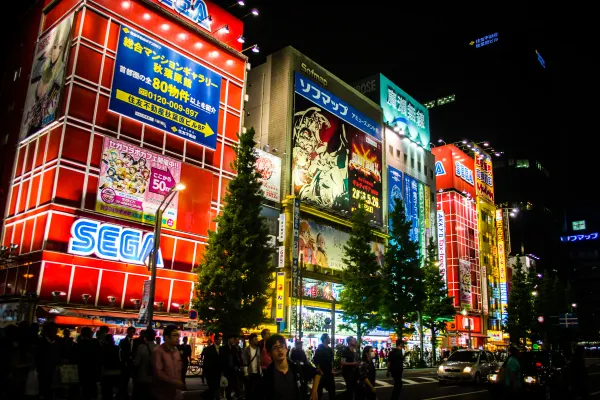 Brightly illuminated arcade buildings above a crowded night street