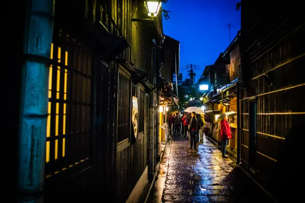 Warm lights reflecting on a narrow wet alley at dusk