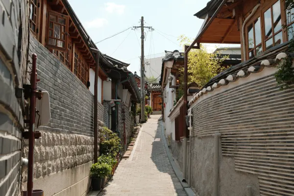 A sunlit uphill alley between tiled roofs and brick walls
