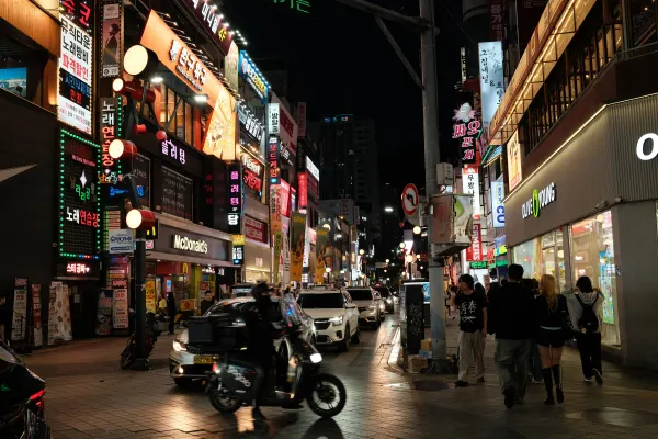 A busy night street lined with brightly illuminated shop signs