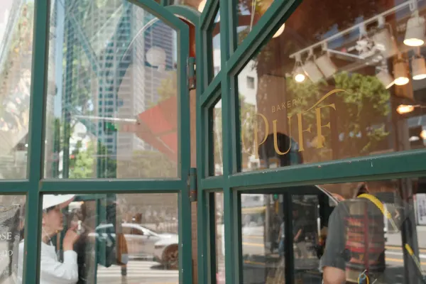 Reflections and warm interior lights behind a turquoise cafe window