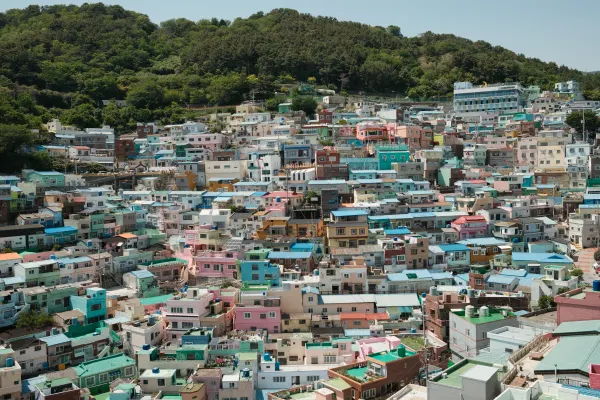 Pastel-coloured houses packed across a green hillside