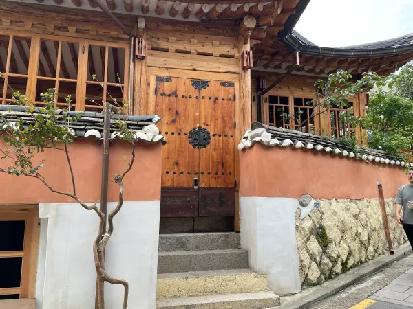 Warm wooden doors and tiled roofs behind an orange wall