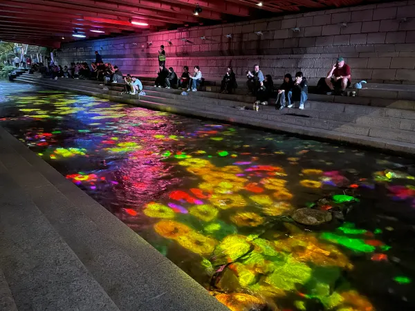 People beside rainbow reflections in Cheonggyecheon stream, Seoul