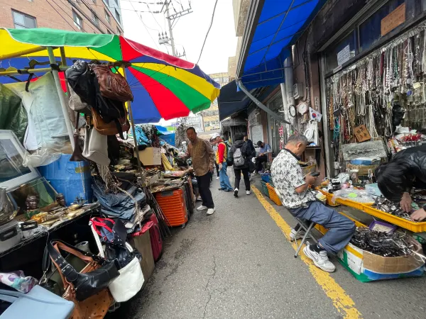An umbrella shading a narrow outdoor market lane