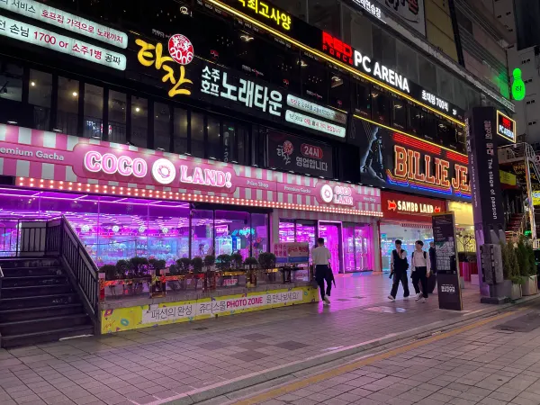 Purple neon glowing across a shopfront at night in Busan