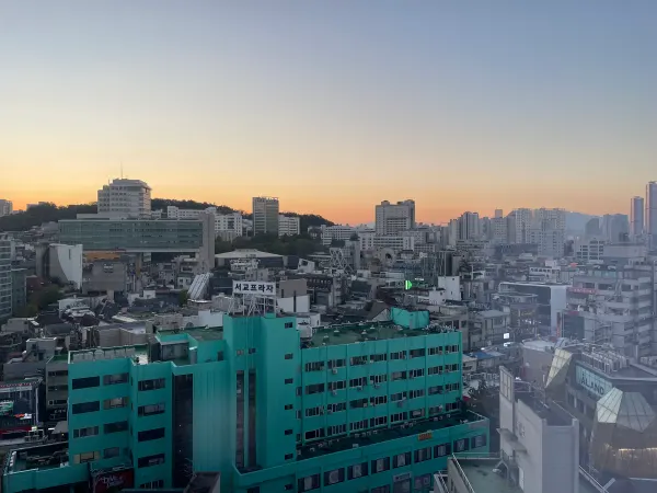 The Seoul skyline beneath a soft orange sunset