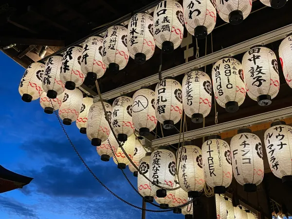 Rows of white paper lanterns against a deep blue evening sky