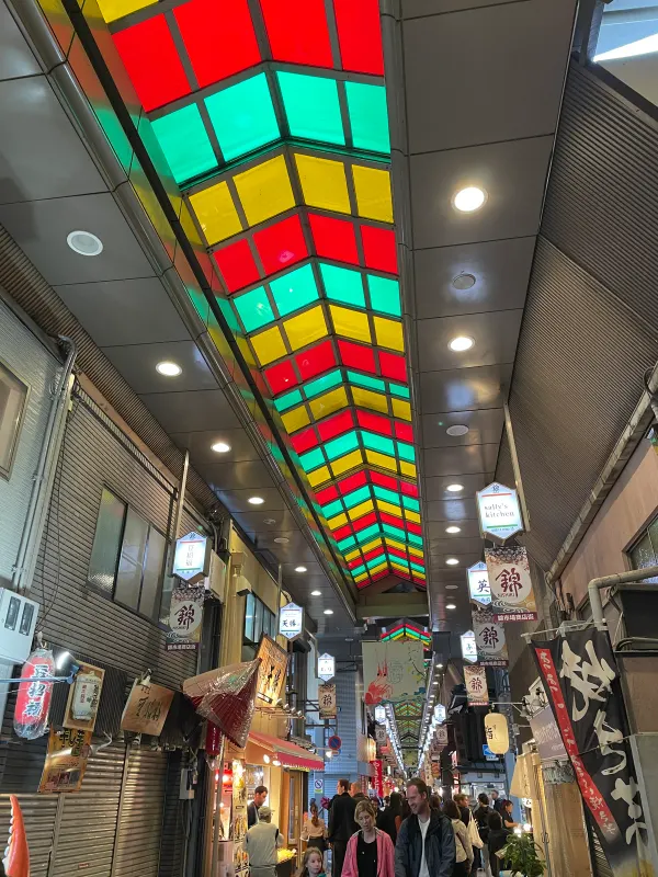 A covered market beneath panels of coloured glass