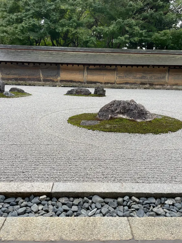 Raked gravel and moss-covered stones in a temple garden