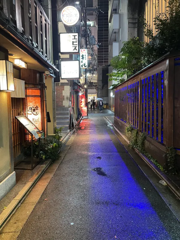 Blue and amber light falling across a narrow alley at night