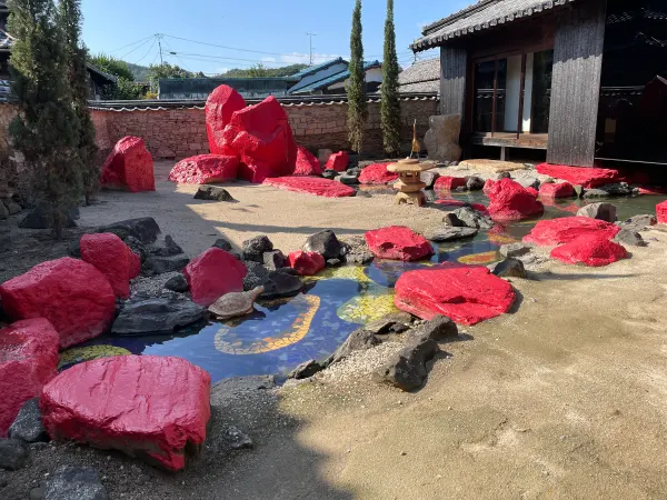 Bright red stones arranged around water in an art courtyard