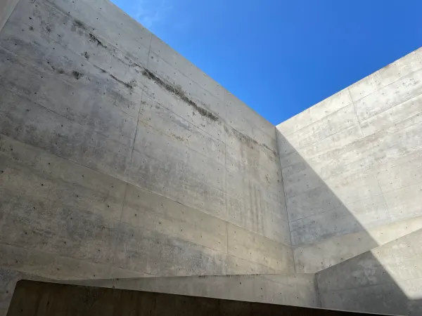 Angular concrete walls framing a patch of blue sky