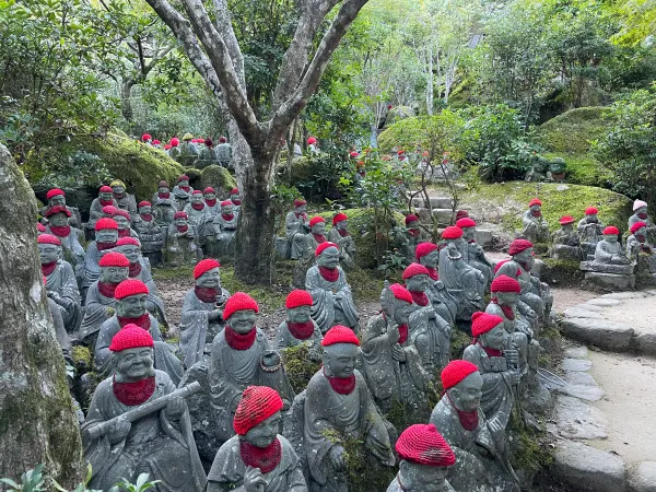 Rows of small stone figures wearing red knitted caps