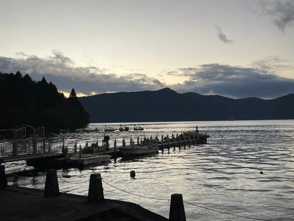 The last light of day over a lake and wooded mountains