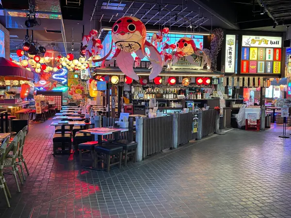 Colourful lanterns and food counters around empty tables in an entertainment hall