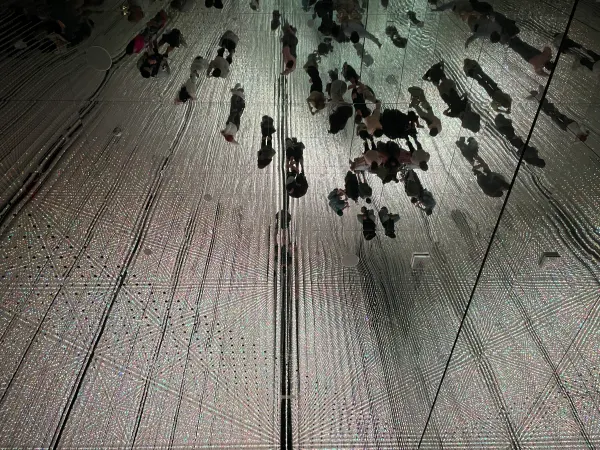 Visitors reflected in a mirrored installation