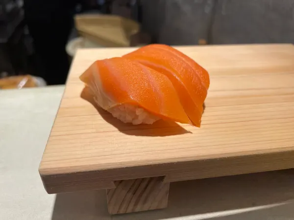 Salmon sushi presented on a small wooden block