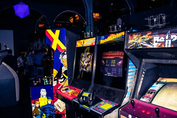 Colourful arcade cabinets glowing inside a dark Portland arcade