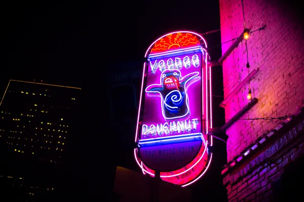 Voodoo Doughnut neon sign glowing at night
