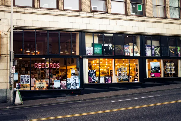 Illuminated record-shop windows along a sloping Portland street
