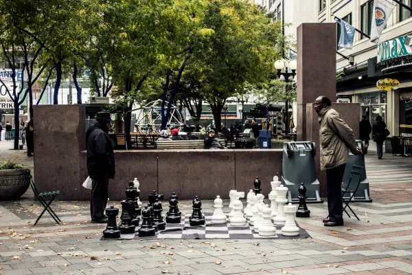 An outdoor chess game with oversized pieces