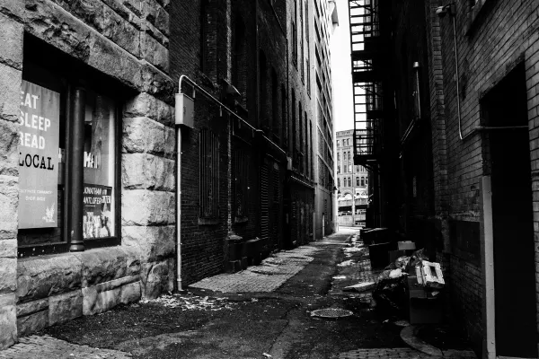 Deep shadows and textured brick walls along a narrow Seattle alley