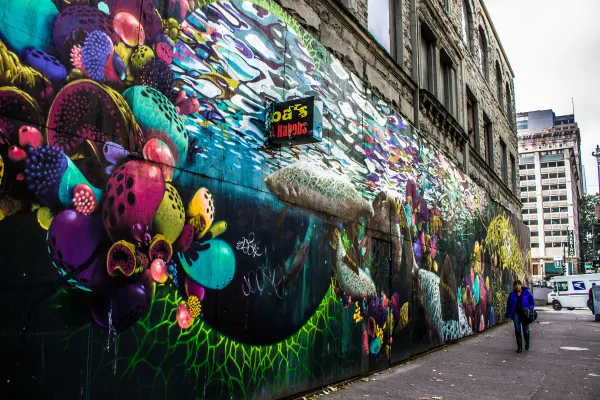 A colourful mural along a city sidewalk