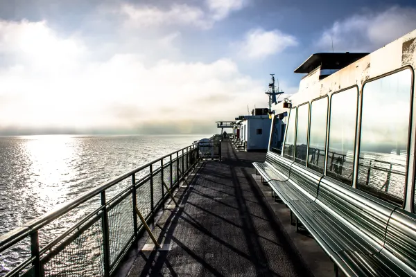 Long shadows along the side deck of a ferry
