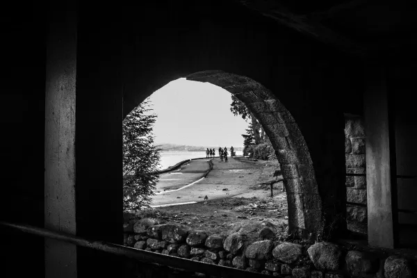 The seawall and walkers framed by a stone arch