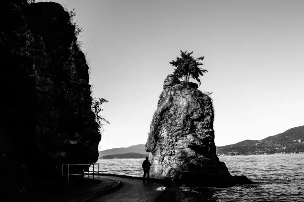 Siwash Rock rising from the water beside Stanley Park