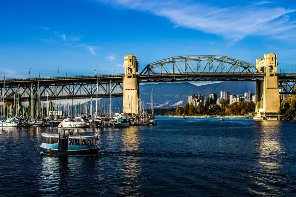A small boat passing beneath a steel bridge