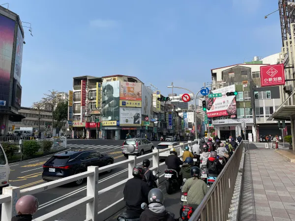 Scooters lined up beside a busy intersection