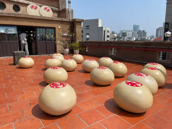 Large bun-shaped sculptures on a red-tiled rooftop