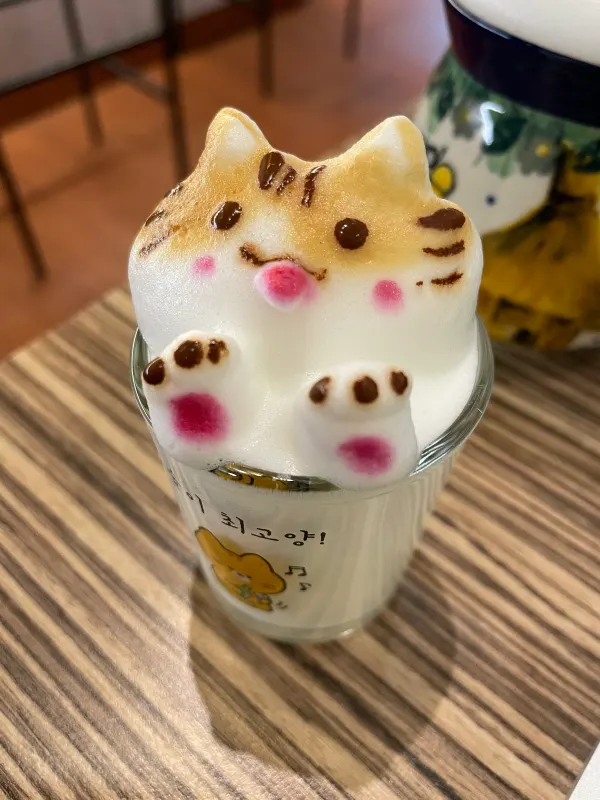 Cat-shaped foam rising above a cup of coffee