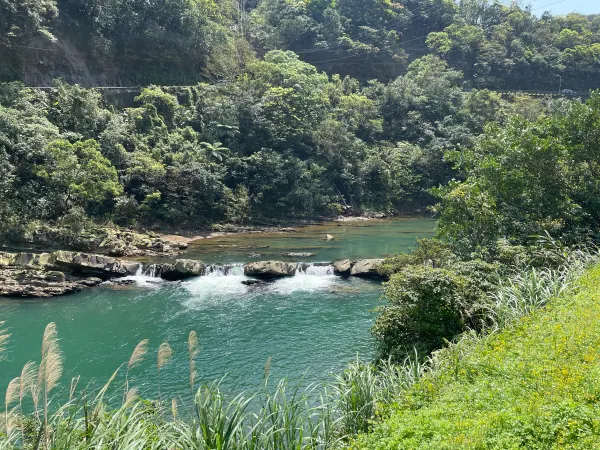 A turquoise river winding beneath wooded hills
